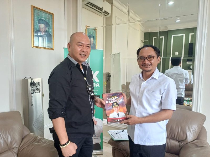 Nikson Nababan menyerahkan buku berjudul 