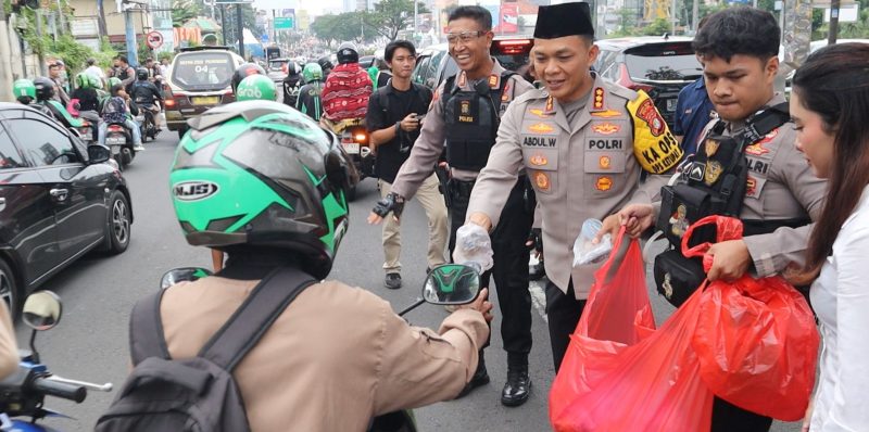 Kapolres Metro Depok, Kombes Pol Abdul Waras saat membagikan takjil kepada para pengendara. Foto : Dokumen Polres Depok

