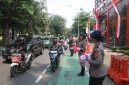 Aksi Simpatik :Banyak pengendara yang secara sukarela menghentikan kendaraan untuk menerima bendera dari anggota Brimob yang membagikannya dengan ramah dan penuh semangat. (HUMAS PMJ)