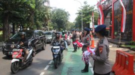 Aksi Simpatik :Banyak pengendara yang secara sukarela menghentikan kendaraan untuk menerima bendera dari anggota Brimob yang membagikannya dengan ramah dan penuh semangat. (HUMAS PMJ)