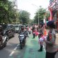 Aksi Simpatik :Banyak pengendara yang secara sukarela menghentikan kendaraan untuk menerima bendera dari anggota Brimob yang membagikannya dengan ramah dan penuh semangat. (HUMAS PMJ)